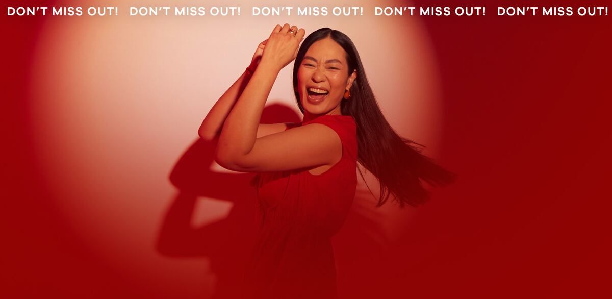 Woman wearing red dress, in front of a red background