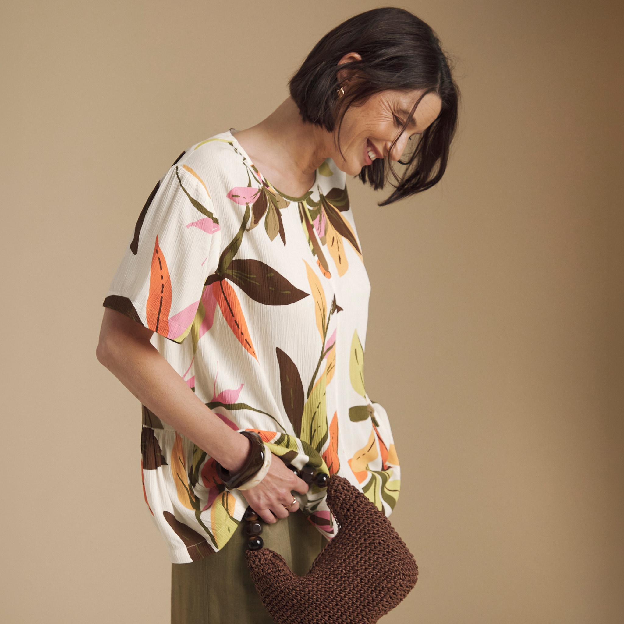 A lady wearing a floral begie top.