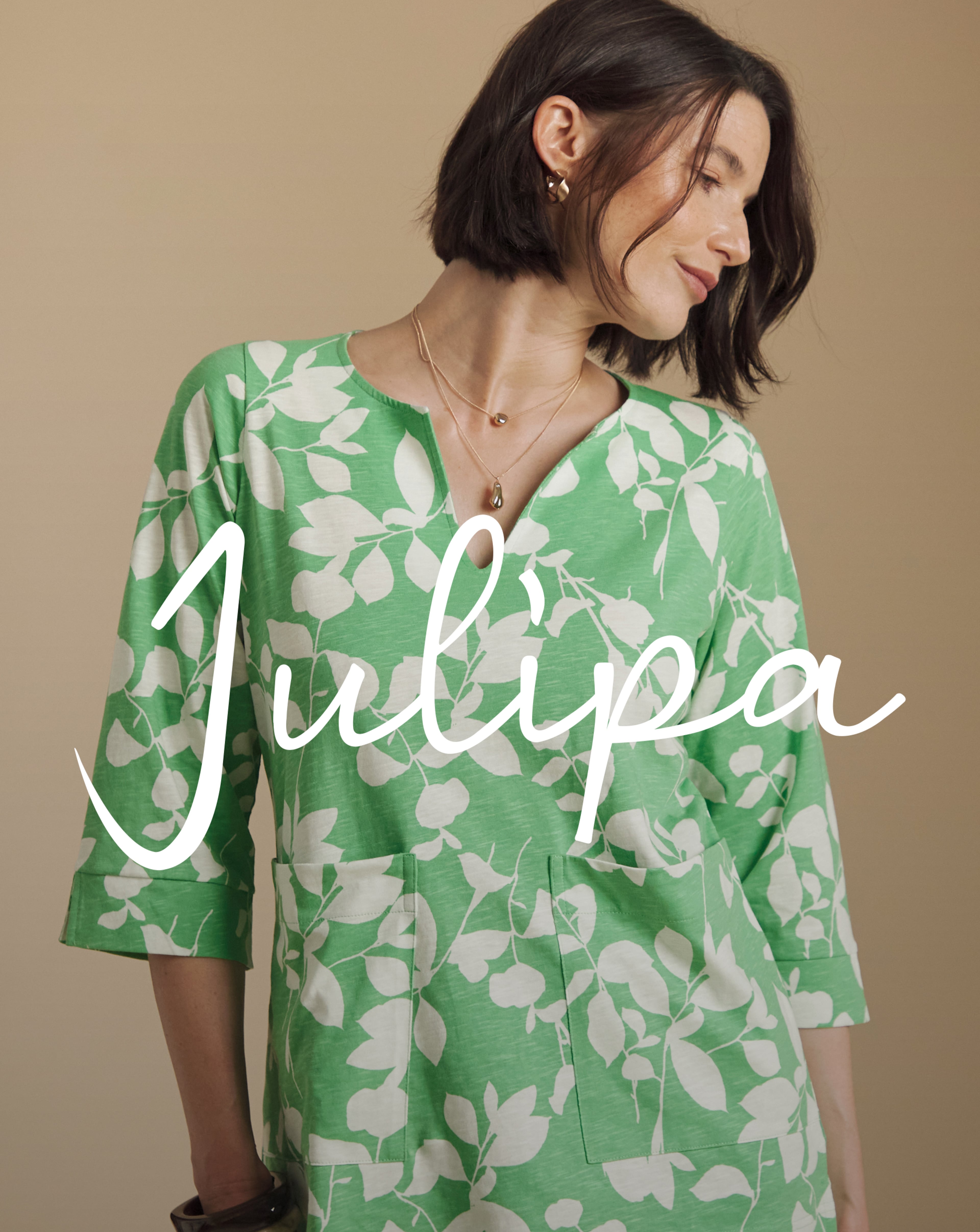 Person wearing a green and white Julipa tunic top.