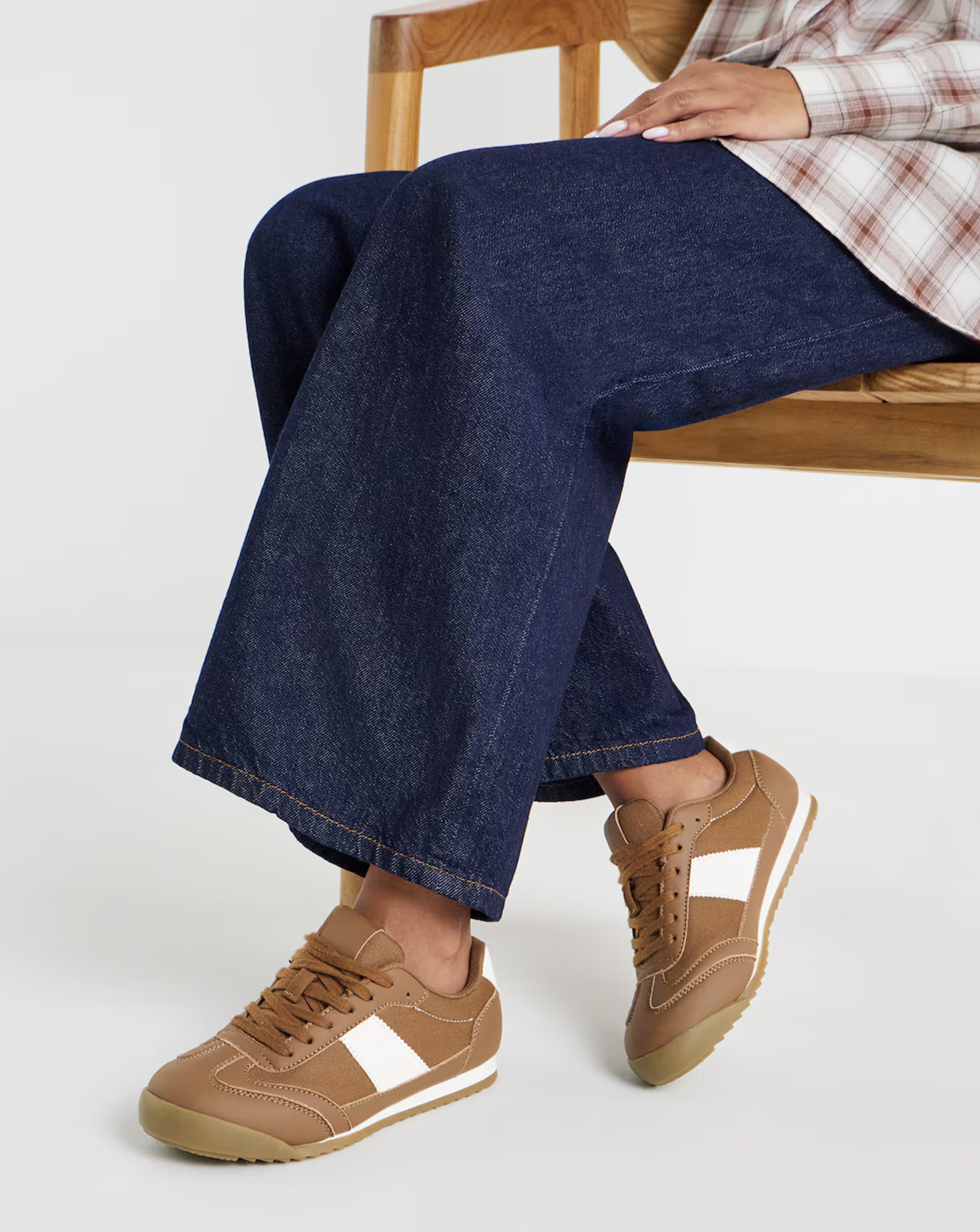 Model is wearing a pair of Storm Classic Retro trainers with blue jeans.