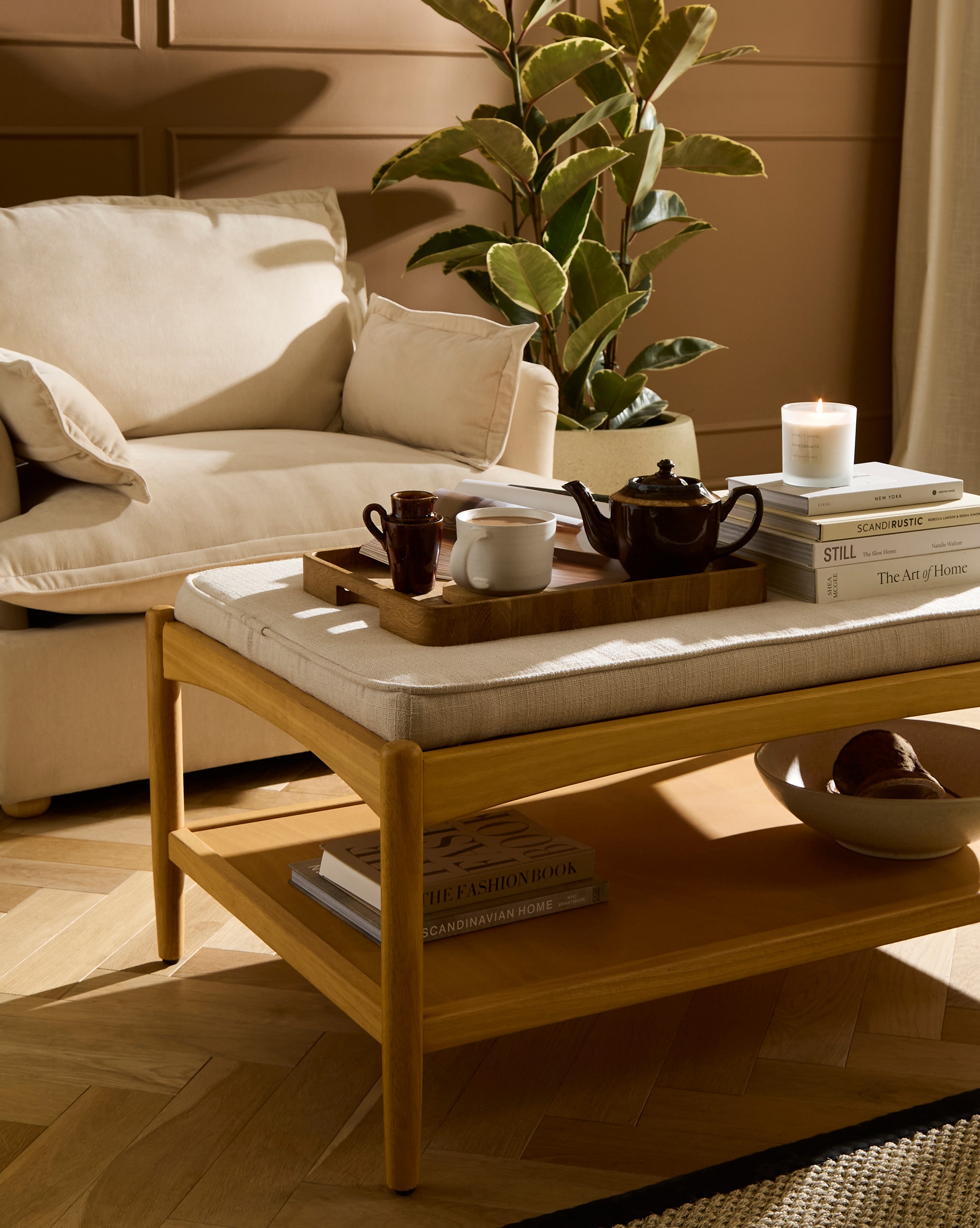 A livingroom with a beige single arm chair and a small coffee table with drinks on it.