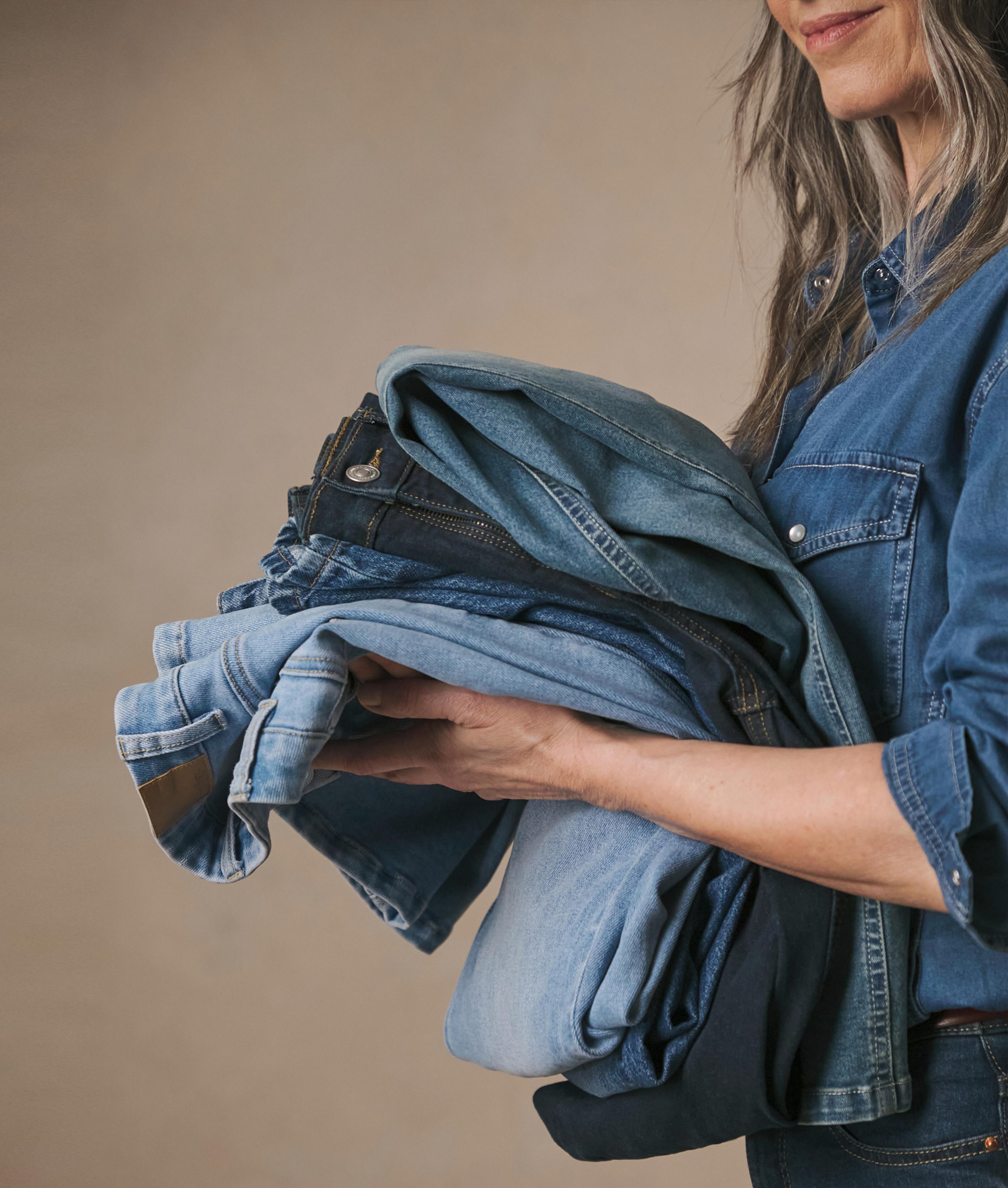 Woman carrying various denim jeans