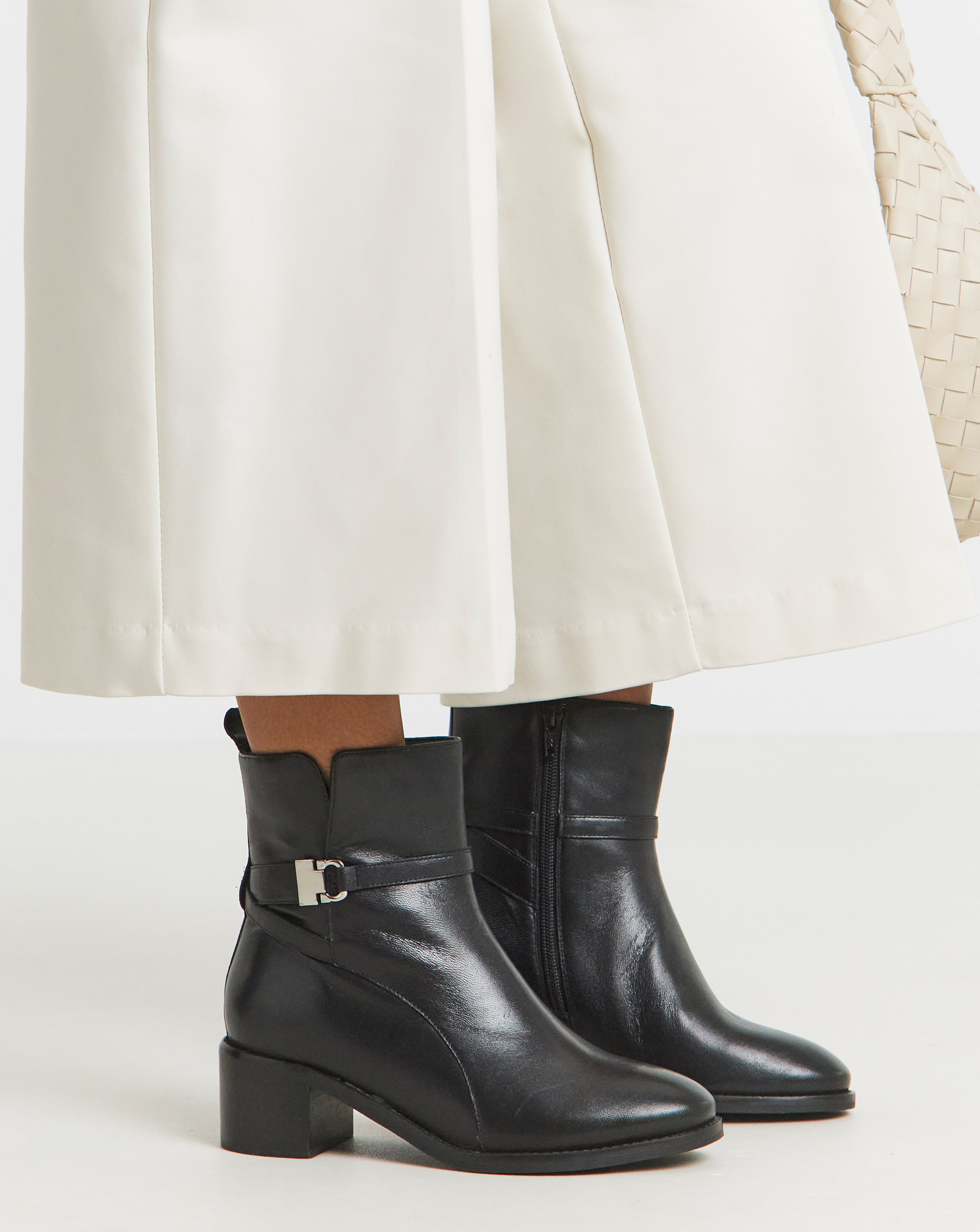 A close-up of black wide fit leather ankle boots