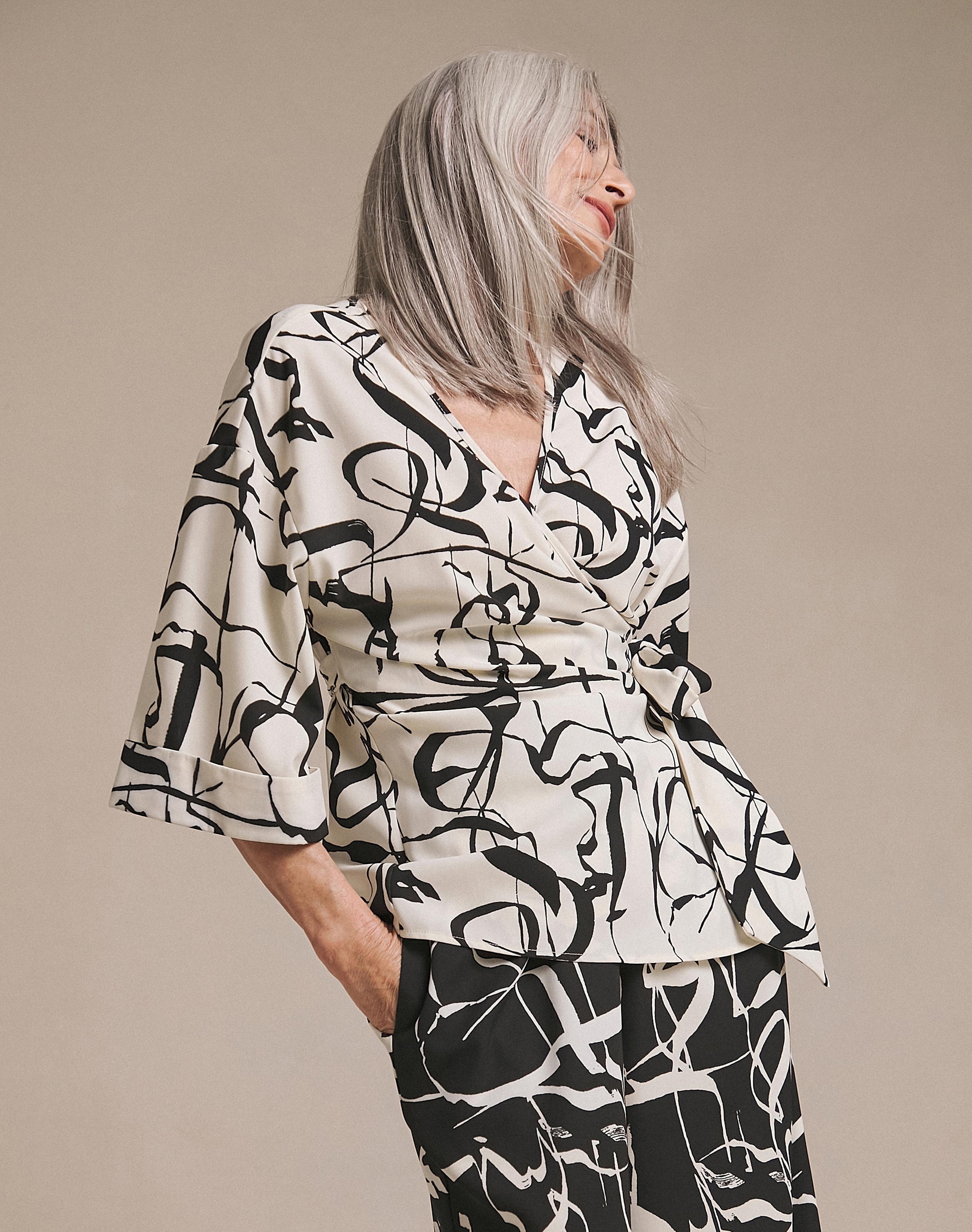 Woman wearing a white and black wrap around blouse