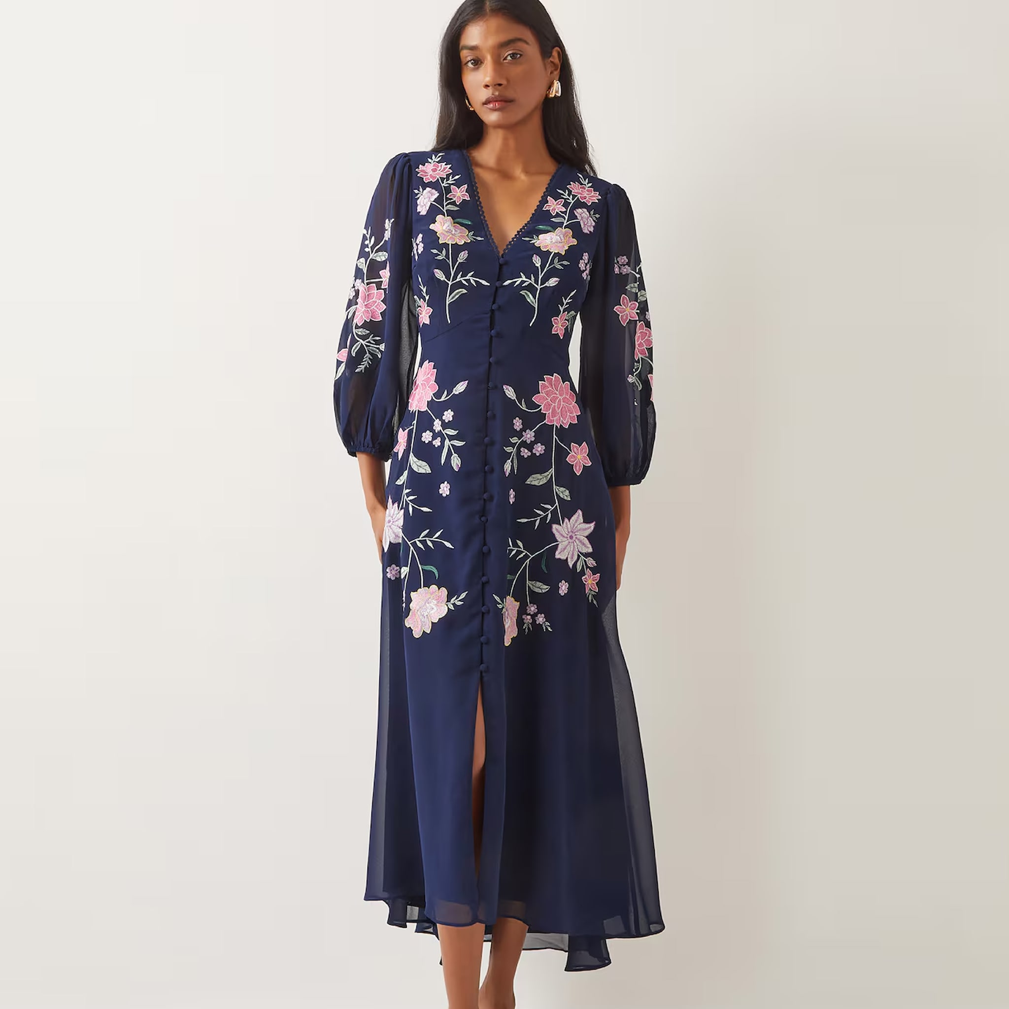 A woman stood wearing a patterned flowery blue dress
