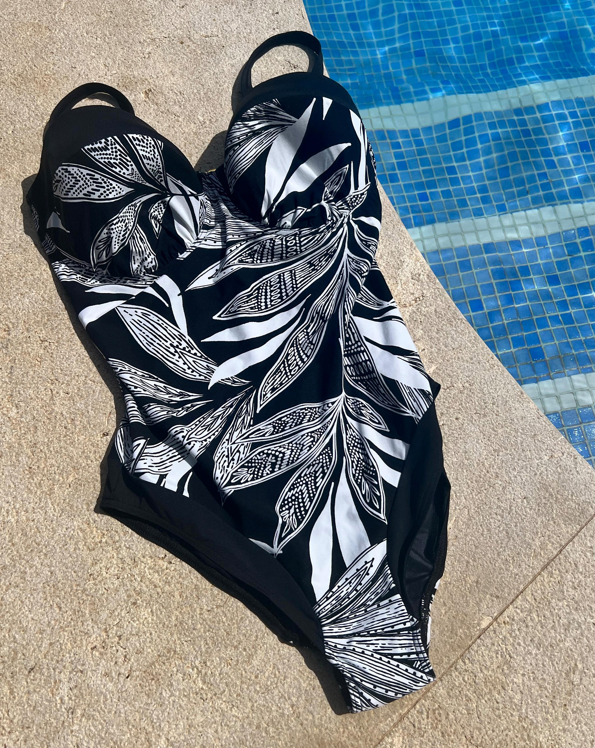 Black swimsuit next to a hotel pool