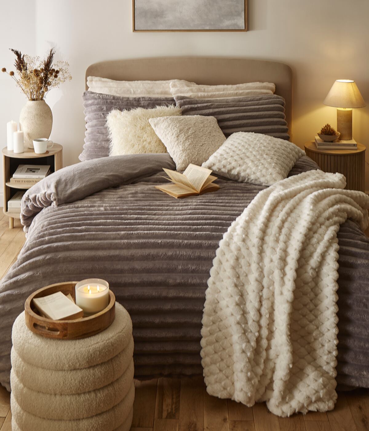 A cosy bedroom scene with fleece bedding and throws in brown and beige colours