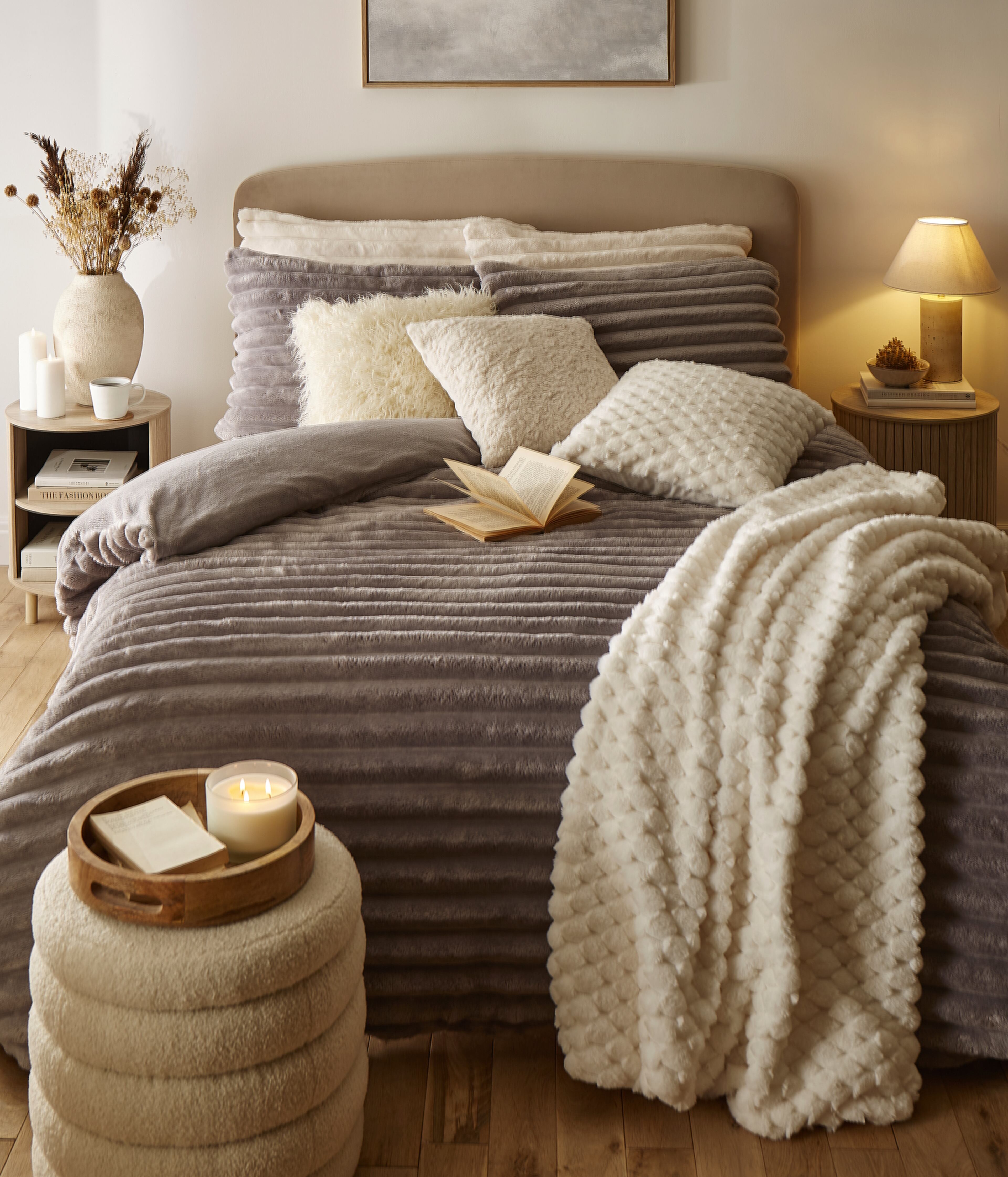A cosy bedroom scene with fleece bedding and throws in brown and beige colours