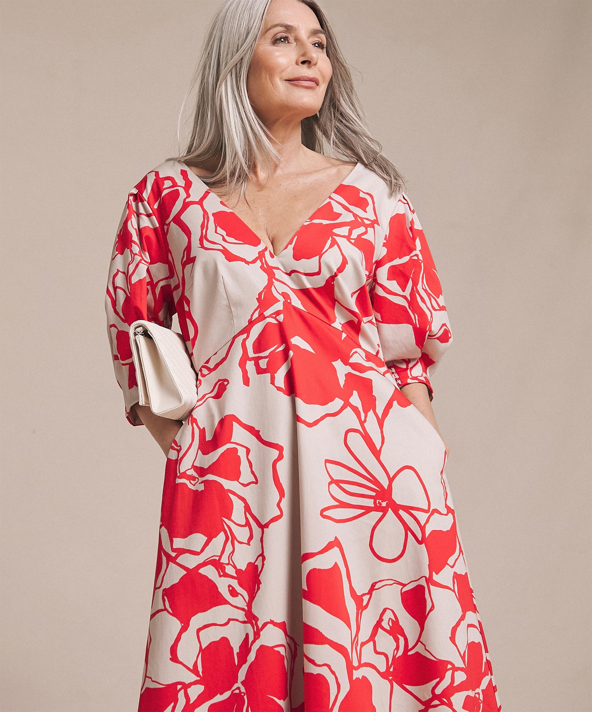 A model wearing a red and cream loose fitting dress