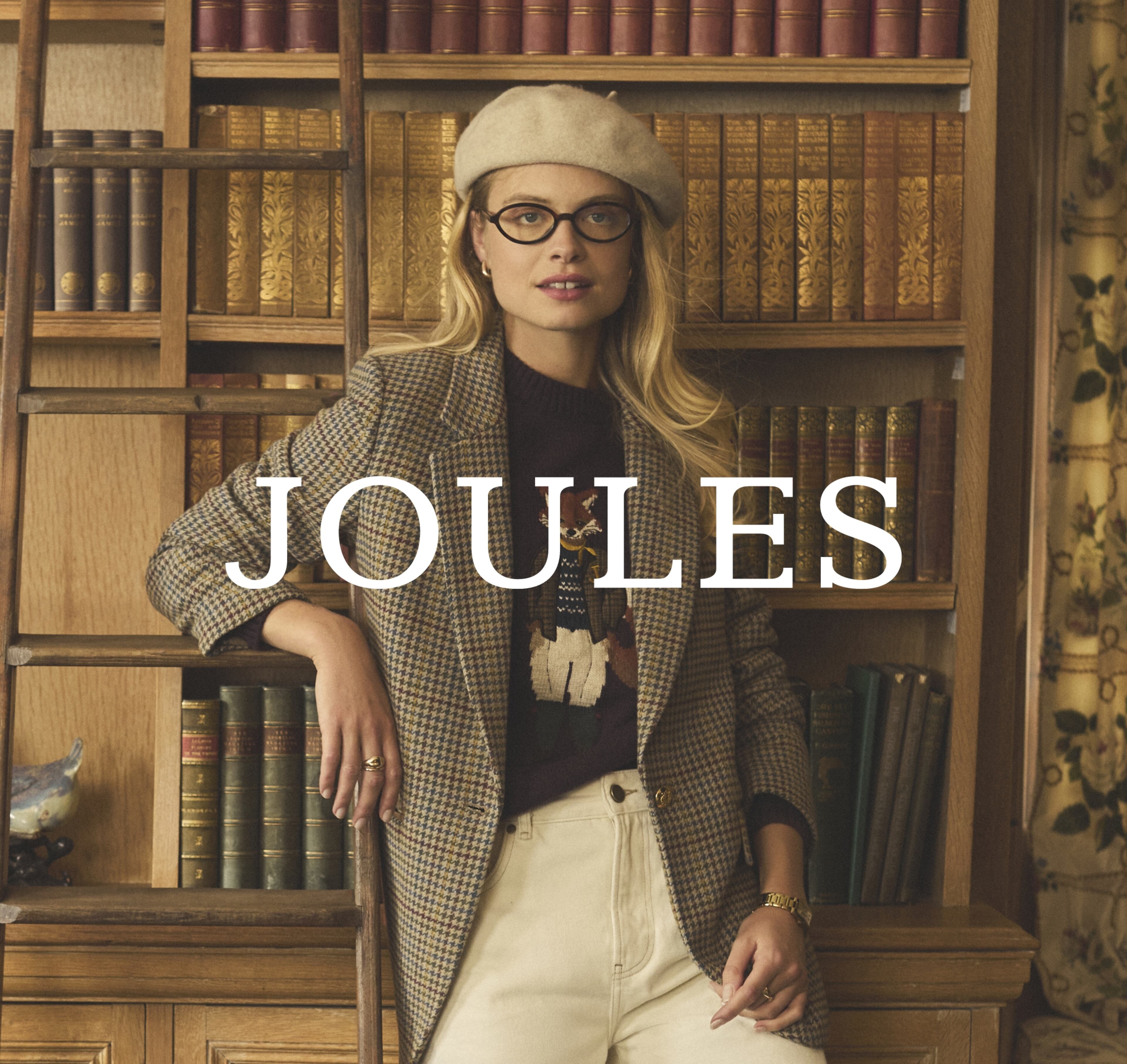 Stylish Woman In Library Setting Wearing Beret, Glasses, and Plaid Blazer for Fashion Editorial