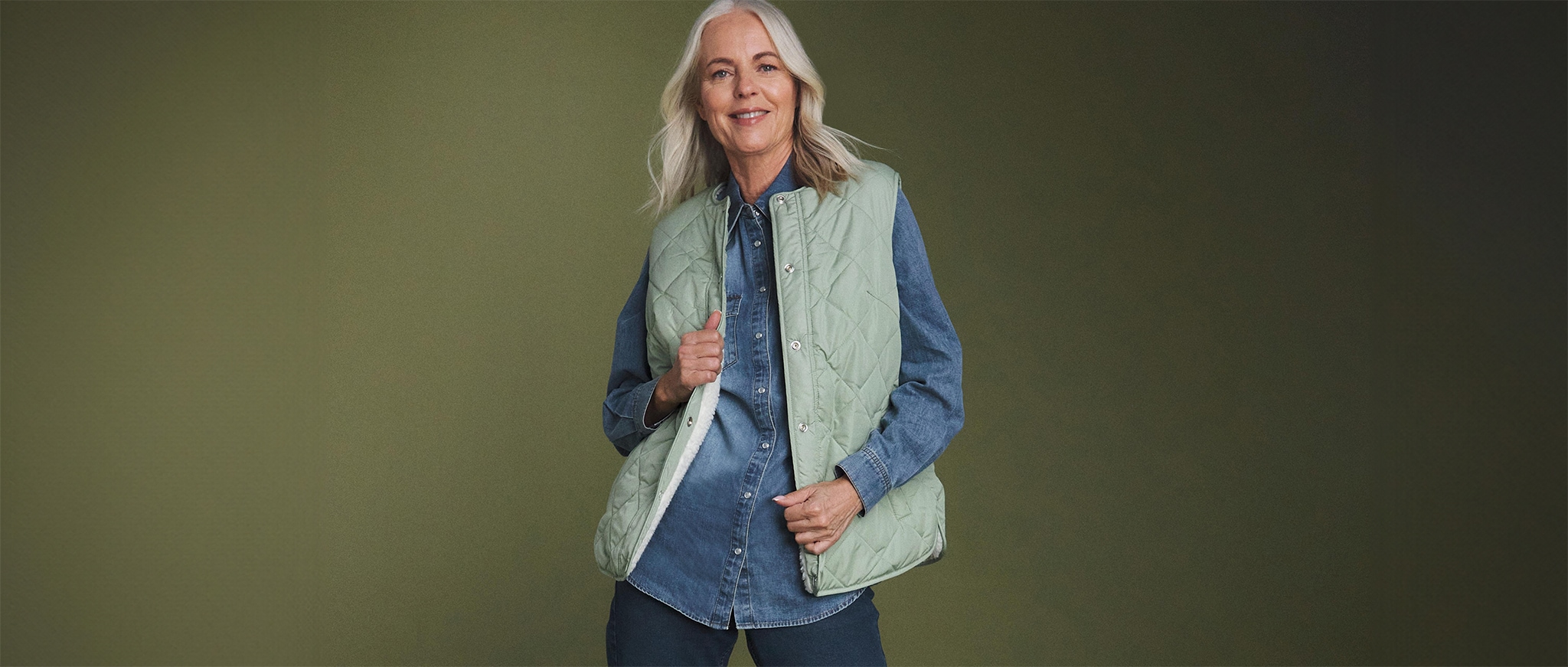 Lady wearing a blue denim shirt and a mint green gilet