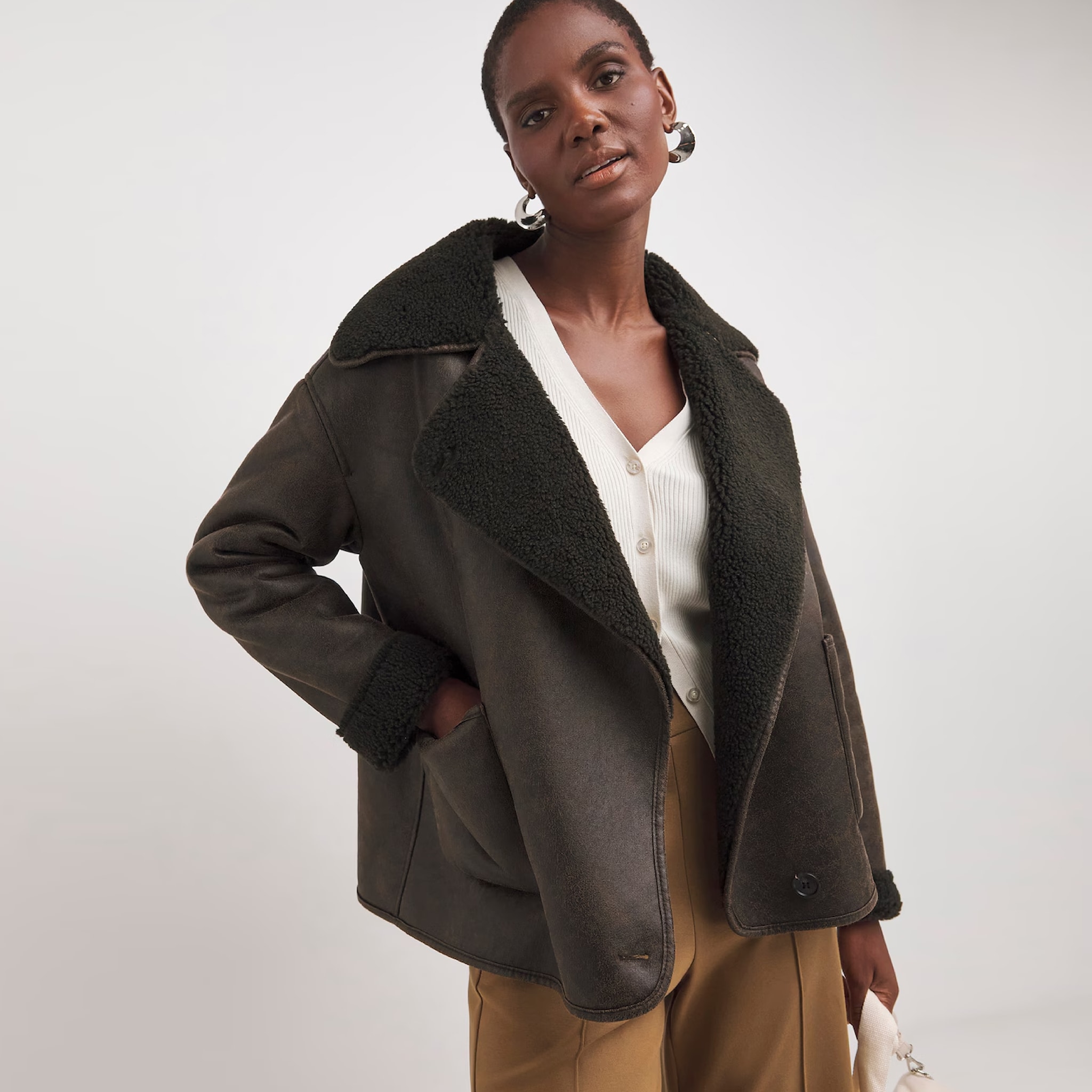 A woman wearing a brown leather jacket with lambswool collar